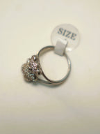 The teddy bear ring seen from the side with its size tag attached.