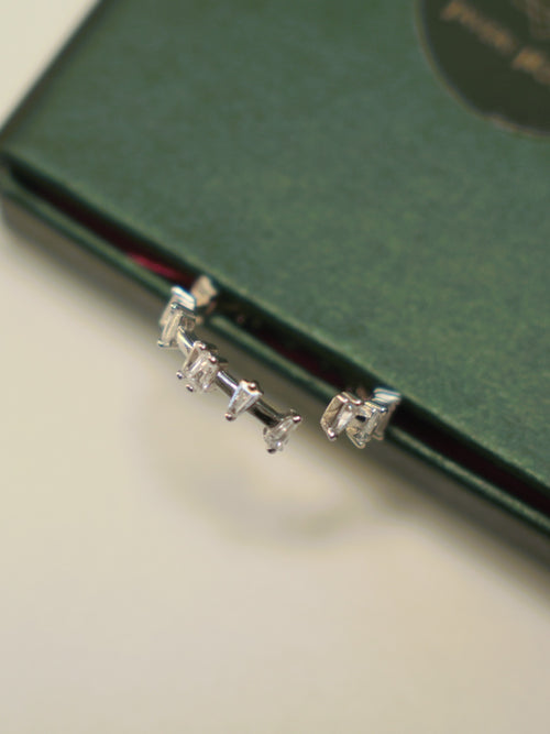 Close view of the prong set baguette and square stones on the open band ring.