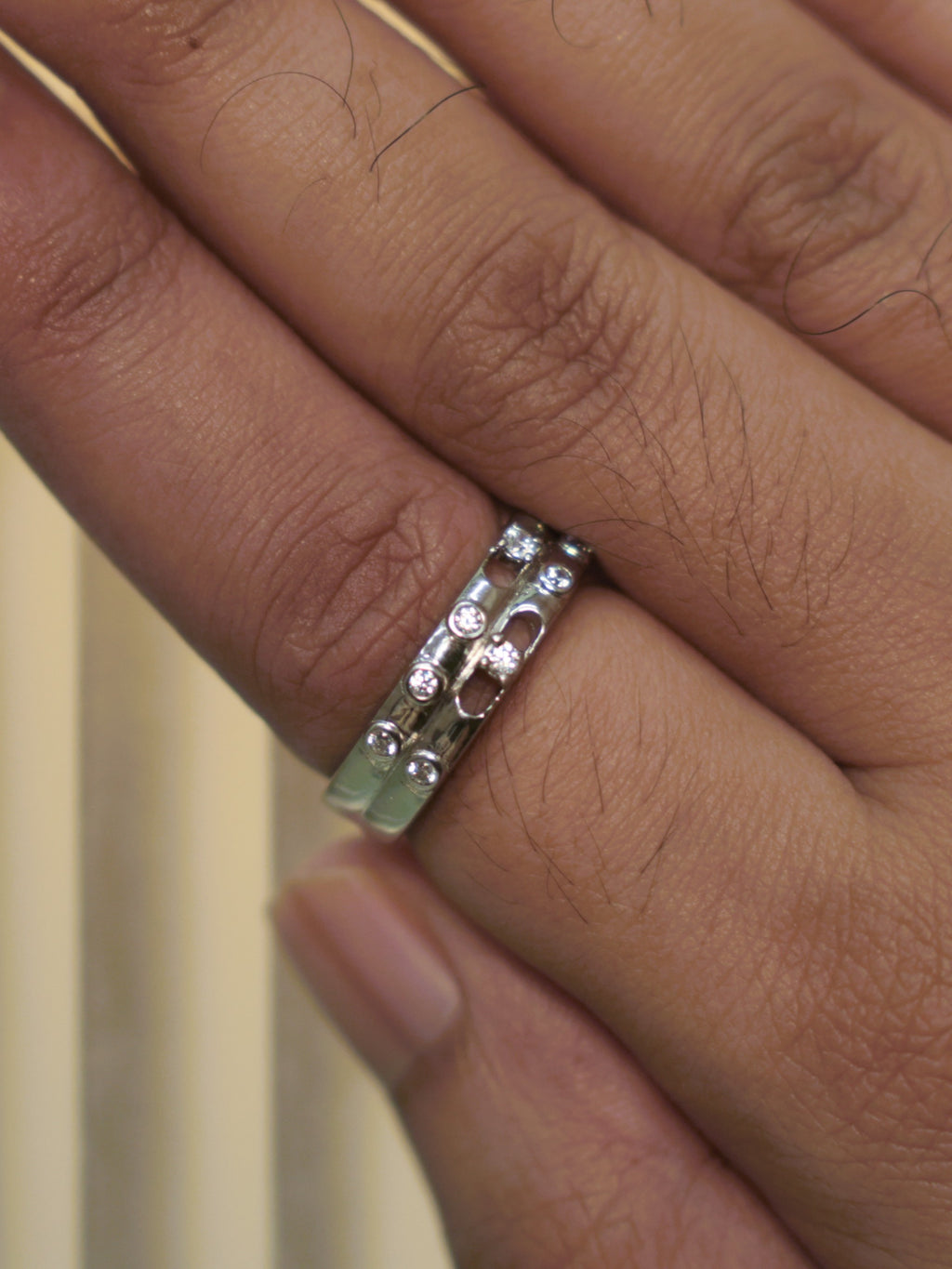 The double row band ring worn on a hand, showing its width on the finger.