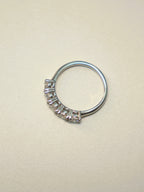 Side view of the five stone ring, showing the shared prongs and the plain band.