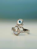 Sterling silver Om ring with a round blue and white evil eye disc above the symbol.