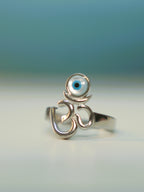 Sterling silver Om ring with a round blue and white evil eye disc above the symbol.