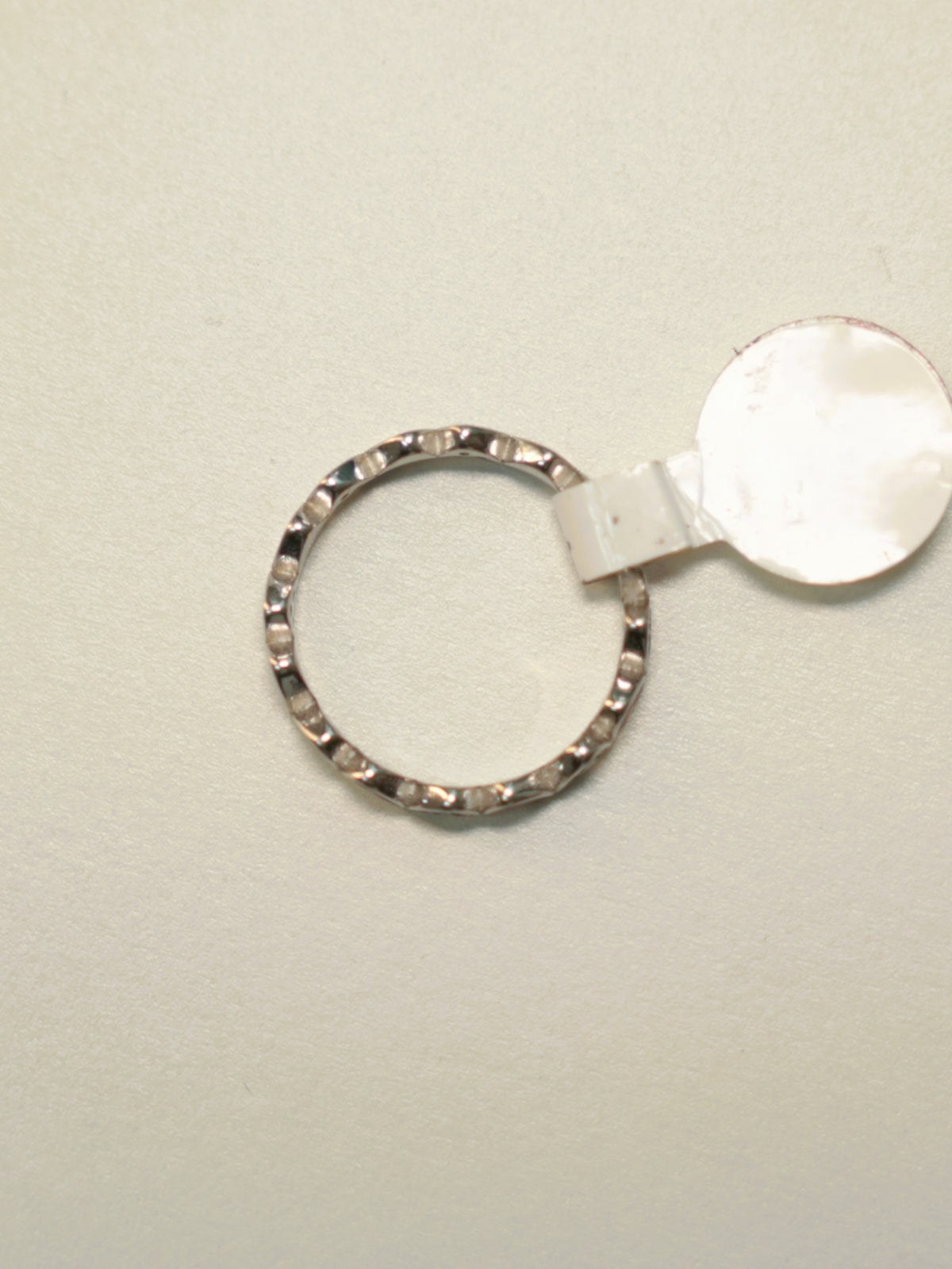 The heart band ring lying flat with its size tag attached, showing the hearts running around the band.