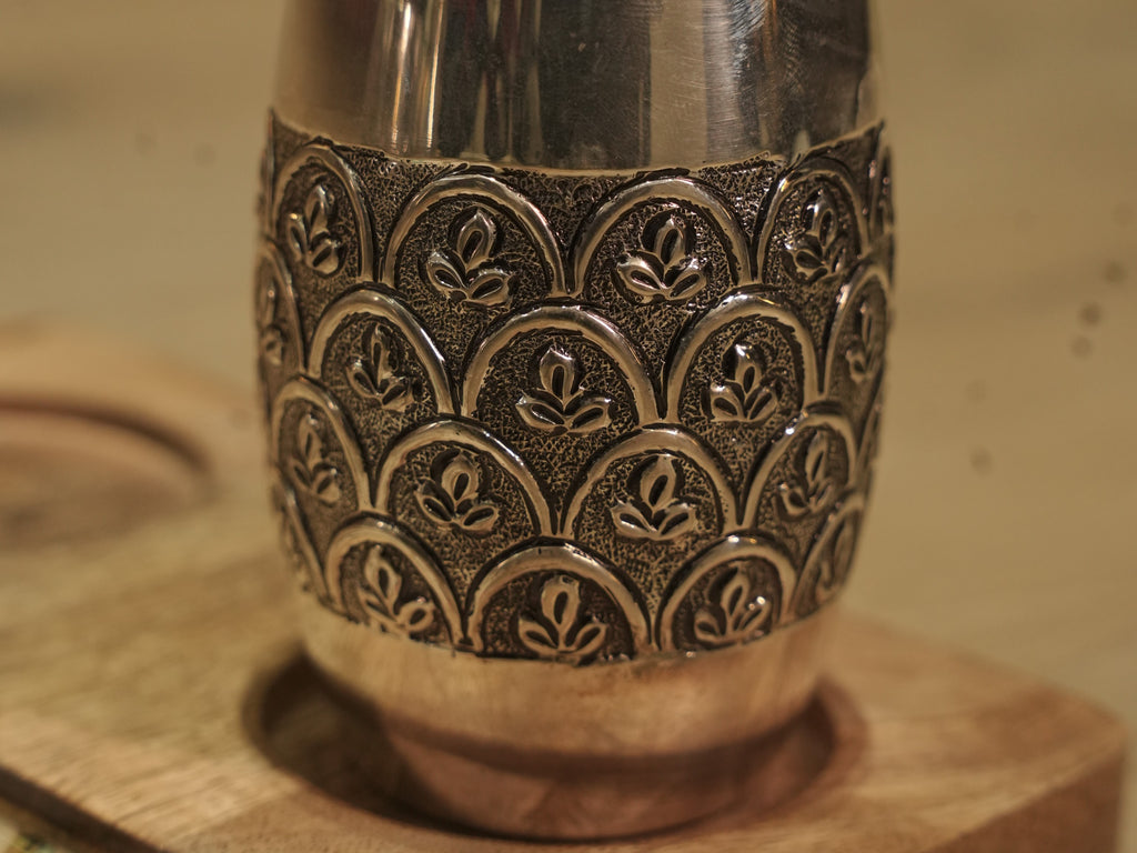Top angle over the pair of silver drinking glasses, showing the bright plain rims.