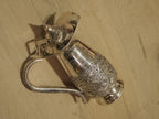 The silver jug with its hinged lid raised, showing the plain polished interior.