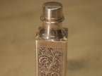 The silver water bottle with its screw cap removed, resting beside it.