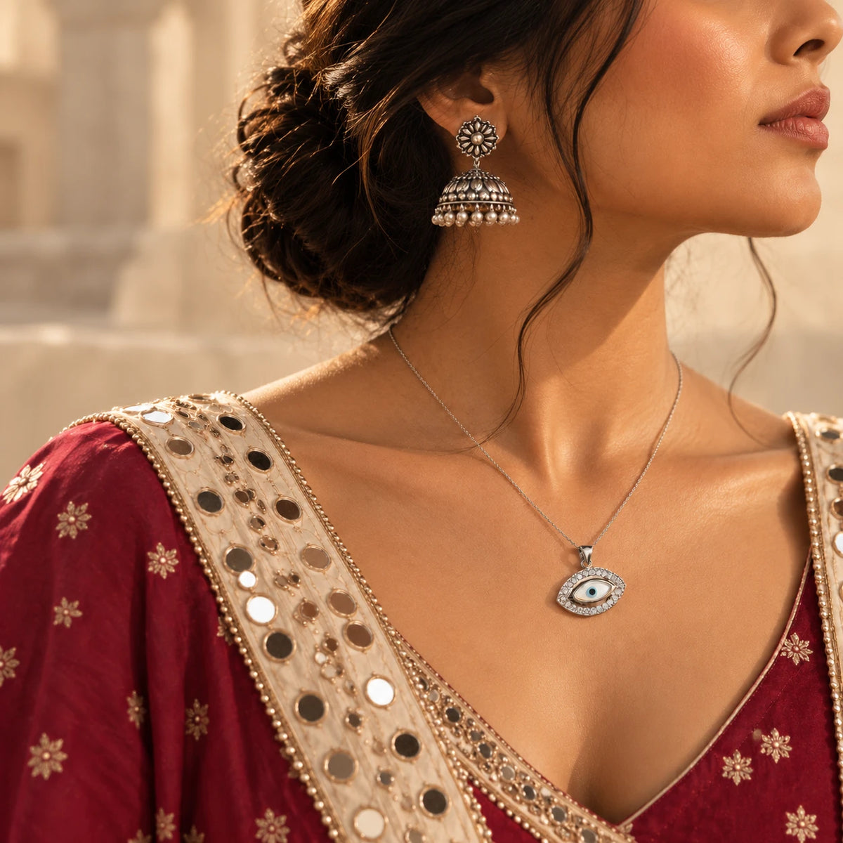 Oxidised silver jhumka with pearl fringe and an evil eye pendant on a fine chain